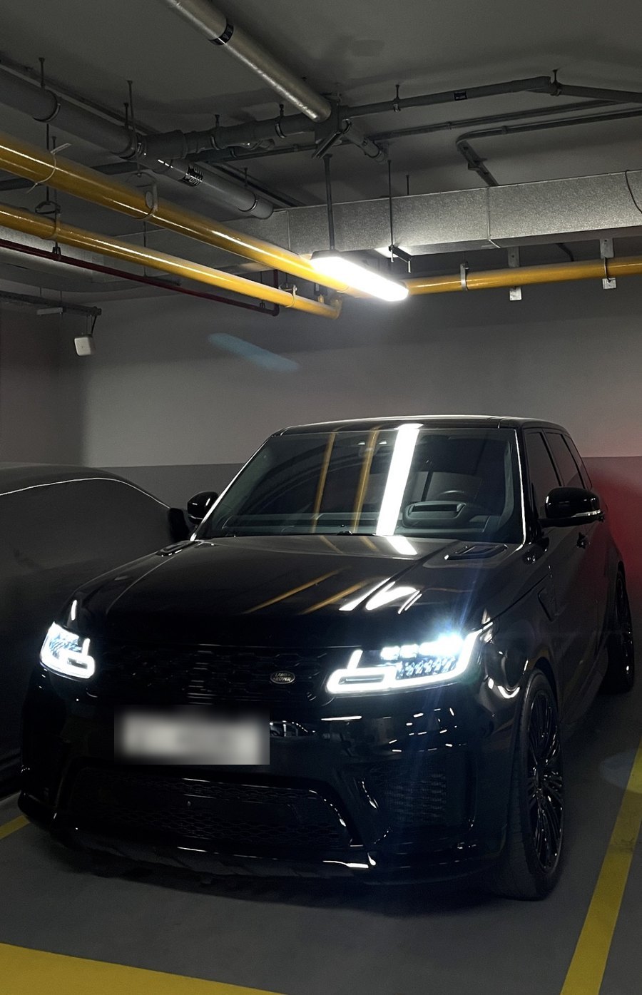 Black Range Rover Sport under garage lights